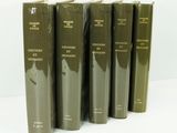 six livres verts empilés les uns sur les autres sur une surface blanche