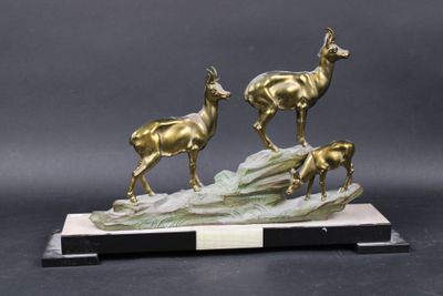 sculpture en bronze représentant trois cerfs sur un rocher, avec un socle noir