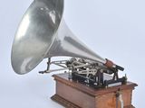 a silver and black gramphone sitting on a wooden stand