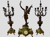 une statue représentant une femme tenant une horloge, à côté de trois lustres
