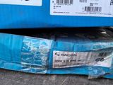 a blue box with a label on it sitting on top of a pile of other boxes