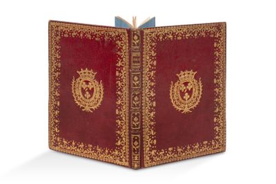 un vieux livre à la couverture rouge ornée d'un emblème doré