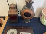 une table sur laquelle se trouvent divers objets, notamment une horloge, une lanterne et d'autres objets