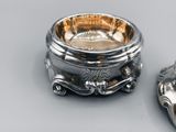 a silver bowl and a silver spoon on a table