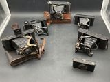 Plusieurs anciens appareils photo sont disposés en cercle sur une table