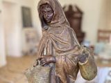 a statue of a woman holding a basket in a living room