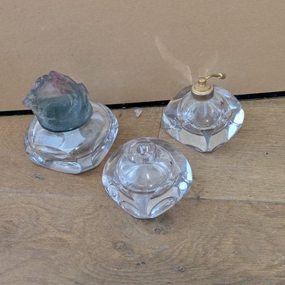 three glass candlesticks sitting on a wooden floor