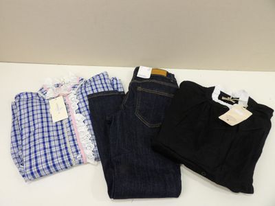 trois paires de jeans et une chemise posées sur une table