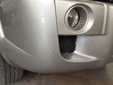 a close up of a car ' s front bumper with the lights on