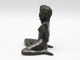 bronze sculpture of a woman sitting on the ground with her legs crossed