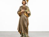 a statue of jesus holding a staff in a white room