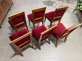four chairs with red upholstered cushions sit on a tiled floor