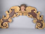 une statue d'ange au sommet d'une arche en bois