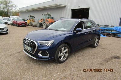 Le SUV Audi bleu est garé devant un immeuble.