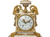 une horloge blanche et or posée sur une table