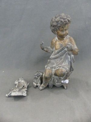 une statue représentant un enfant assis sur une chaise, un livre à la main