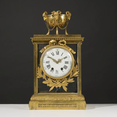 an image of a gold and black clock sitting on top of a white table