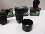 three camera lenses and a lens cup on a table
