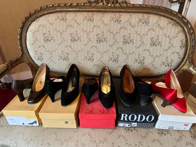 several pairs of women ' s shoes sitting on top of boxes on a chair
