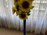 des tournesols jaunes dans un vase bleu devant une fenêtre