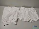 two pairs of white shorts sitting on top of a table