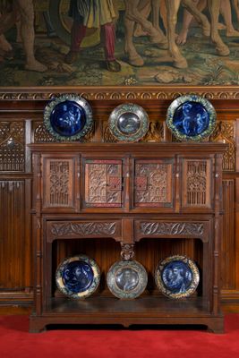 une armoire en bois sur laquelle sont posées des assiettes bleues