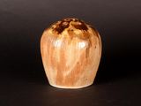 a brown and white vase sitting on a black surface