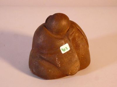 une petite figurine représentant une personne, sur laquelle est collé un autocollant