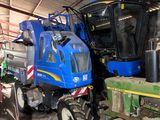 a blue tractor and a green tractor in a barn