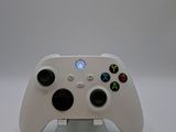 a close up of a white controller on a stand