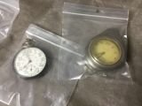 a pocket watch and a pocket watch sitting on a table
