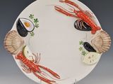 a plate with a lobster, shrimp, and lemon on it