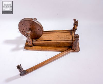 une toupie en bois munie d'un manche en bois, posée sur une surface blanche