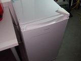 a white refrigerator and a red fire hydrant in a room