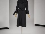 une photo d'un mannequin vêtu d'un manteau et d'une jupe noirs