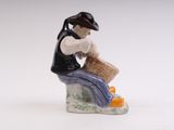 a figurine of a man sitting on a bench