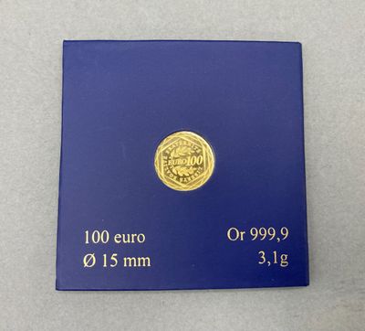un gros plan d'une pièce d'or posée sur une boîte bleue