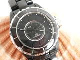 a black watch on a black bracelet on a seashell