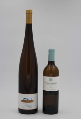 deux bouteilles de vin posées l'une à côté de l'autre sur une surface blanche