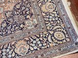 a blue and orange rug on the floor next to a brown chair