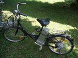 un vélo garé dans l'herbe, avec un panier à l'arrière