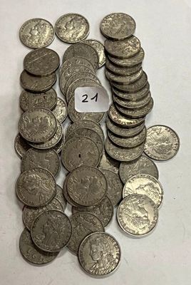 un tas de pièces d'argent posées sur une table sur laquelle figure un chiffre