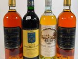 quatre bouteilles de vin sont alignées sur une surface blanche