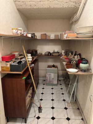 une petite cuisine où le sol est encombré d'objets