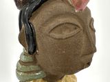 a ceramic figurine of a woman wearing a headdress