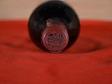 a bottle of wine sitting on a red cloth