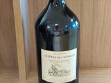 une bouteille de vin posée sur une étagère à côté d'une paire de ciseaux