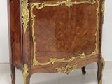 a small wooden cabinet with a marble top on a white floor