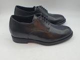 a pair of black leather shoes on a white surface