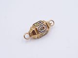 a close up of a gold plated charm with a flower design on it